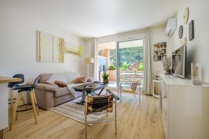a living room with a couch and a table at Appartement Vaugrenier Presidences in Villeneuve-Loubet
