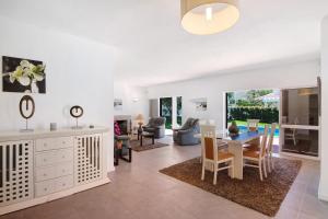 a dining room and living room with a table and chairs at Villa Lynn - Quadradinhos in Almancil
