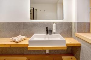 a bathroom with a white sink and a mirror at Chalet Pieri - Appartamento Bedogn in Bormio