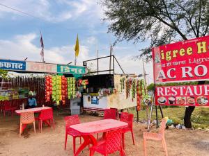 a table and chairs in front of a food stand at Ligree Hotel and Restaurant in Jatwāra
