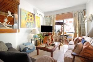 a living room with a couch and a table at T3 Duplex Albufeira in Olhos de Água
