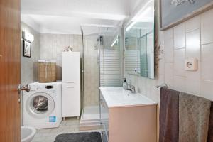 a bathroom with a washing machine and a sink at T3 Duplex Albufeira in Olhos de Água +19 photos