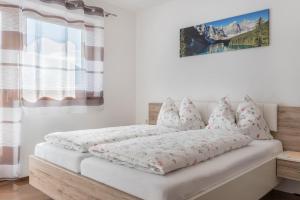 a bed with white sheets and pillows on it at Trojer Apartment 2 in Sarntal