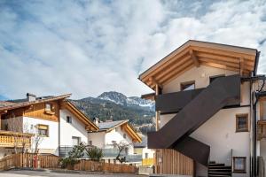 a house in the mountains with a black staircase on it at Trojer Apartment 2 in Sarntal