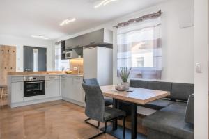 a kitchen and dining room with a table and a couch at Trojer Apartment 2 in Sarntal