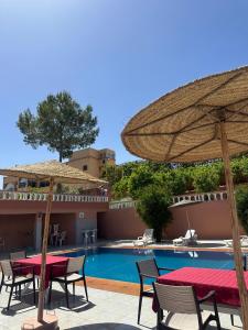 a patio with tables and umbrellas next to a pool at Green Valley Lodge - Atlas Mountains Nature in Taroudant