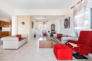 a living room with white furniture and red chairs at White Pearl in Lachania