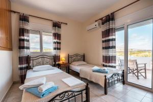 a bedroom with two beds and a balcony at White Pearl in Lachania +22 photos