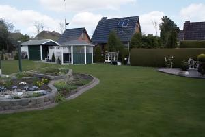 a garden with a house and a yard with a lawn at Ferienwohnung Weise in Schafstedt