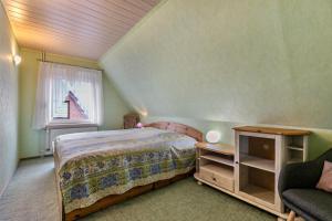 a bedroom with a bed and a chair and a window at Ferienwohnung Weise in Schafstedt