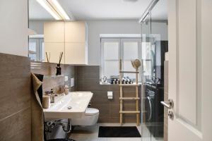 a bathroom with a sink and a toilet and a shower at Lieblingsplatz Ferienwohnung in Bad Tölz +27 photos