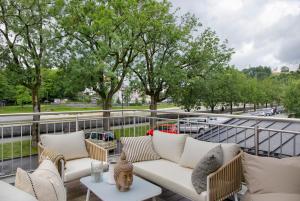 a patio with white couches and tables and trees at Lieblingsplatz Ferienwohnung in Bad Tölz