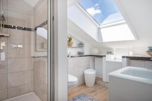 a bathroom with a shower and a toilet and a skylight at Im Spatzennest in Inzell +15 photos