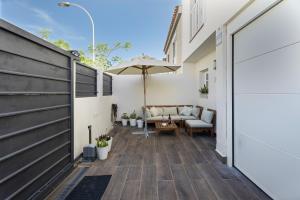 a patio with a couch and an umbrella at Casa el Jable in Guía de Isora