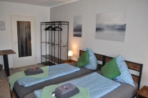 two beds in a room with green and blue pillows at Backbordkajüte am Steinhuder Meer in Wunstorf