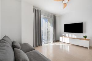 a living room with a couch and a flat screen tv at Coral Beach in Bajamar