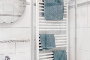 a bathroom with a towel rack with blue towels at Ferienwohnung Zugspitznest in Grainau +22 photos
