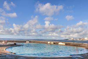 a swimming pool with the ocean in the background at Coral Beach in Bajamar