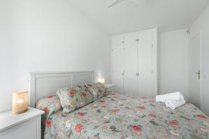 a bedroom with a bed with a floral bedspread at Coral Beach in Bajamar +20 photos