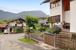 a house with a wooden fence in a village at Ferienwohnung Zugspitznest in Grainau