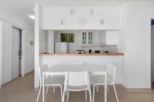 a white kitchen with a white table and chairs at Coral Beach in Bajamar