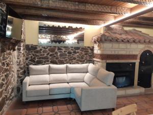 a living room with a couch and a fireplace at El Mirador Del Pedroso in Barbadillo del Pez