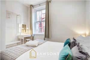 a white bedroom with a bed and a window at Sea You Soon I Seafront Stay in Portsmouth