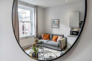 a living room with a couch and a window at Sea You Soon I Seafront Stay in Portsmouth +3 photos