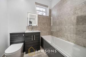 a bathroom with a toilet and a tub and a sink at Sea You Soon I Seafront Stay in Portsmouth
