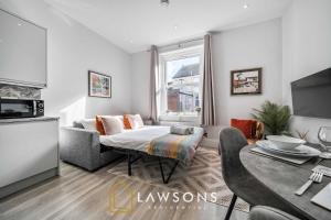 a living room with a couch and a table at Sea You Soon I Seafront Stay in Portsmouth