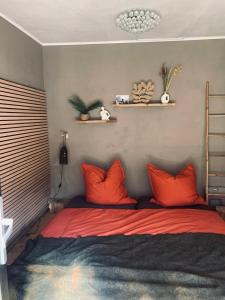 a bed with orange pillows in a bedroom at Il wokini in Castel Vittorio