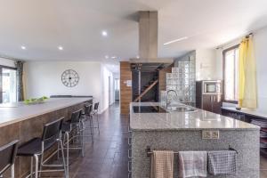 a kitchen with a large island with bar stools at El Arrebol Rural in El Espinar