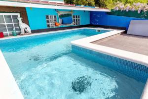 a large swimming pool with a blue wall and a swimming poolvisor at Estúdio Azul in Moledo