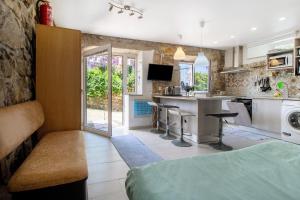 a kitchen and living room with a bed and a counter at Estúdio Azul in Moledo
