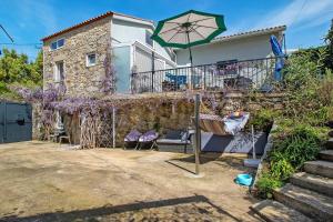 a house with a patio and an umbrella at Estúdio Azul in Moledo