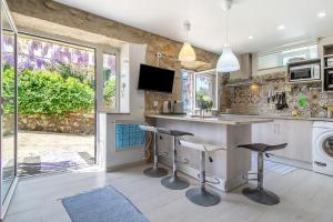 a kitchen with a bar with stools and a tv at Estúdio Azul in Moledo
