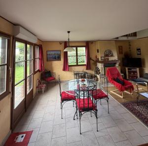 a dining room with a table and red chairs at Les Buissons in Saint-Pierre-le-Vieux