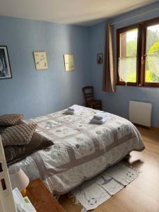 a bedroom with a large bed in a blue wall at Les Buissons in Saint-Pierre-le-Vieux