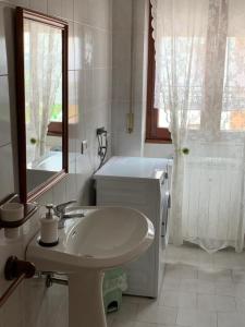 a bathroom with a sink and a toilet and a window at Serravalle Shopping - Outlet in Serravalle Scrivia +11 photos