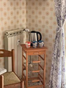 a table with a tea kettle on it next to a curtain at Serravalle Shopping - Outlet in Serravalle Scrivia