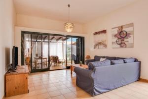 a living room with a blue couch and a tv at El Cortijo in La Oliva