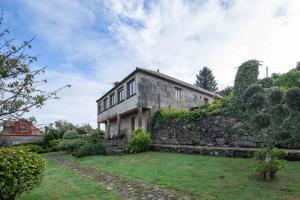 a large stone building with a yard in front of it at Casa Rural Magina in Fornelos de Montes