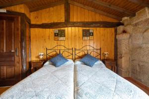 a bedroom with a bed with blue pillows at Casa Rural Magina in Fornelos de Montes