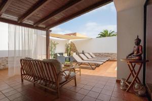 a patio with chairs and a statue on a table at El Cortijo in La Oliva