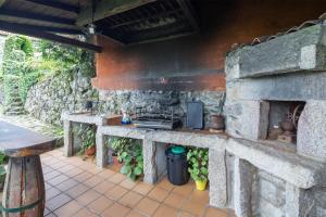 an outdoor kitchen with a stone wall at Casa Rural Magina in Fornelos de Montes