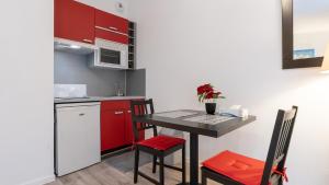 a small kitchen with a table and red cabinets at Virginia N104 - ST2 in Grasse +2 photos