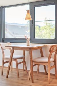 a wooden table and chairs in a room with a window at Alte Seifensiederei - Lallaji in Bad Tölz +15 photos