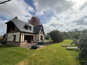 a black and white house with a bench in a yard at Les Buissons in Saint-Pierre-le-Vieux