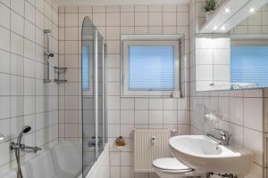 a bathroom with a sink and a toilet and a tub at Ferienwohnung Tannenblick 3-1 in Oberhof +15 photos
