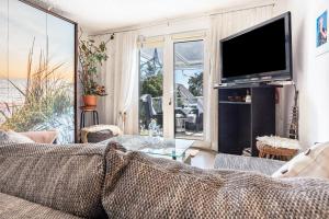 a living room with a couch and a tv at Ostseeblick in Kröslin